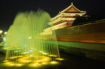 Entrance to the Forbidden City and fountain illuminated at night.