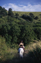 Horse riders on a bridlepath at the foot of the South Downs.