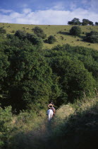 Horse riders on a bridlepath at the foot of the South Downs.