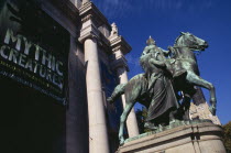 American Museum of Natural History  Central Park West entrance with bronze statue of President Theodore Roosevelt on horseback and exhibition posters.