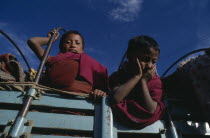 Novice monks looking down from back of truck.