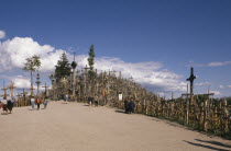 Visitors at ancient pilgrimage site of hill near Siaulial covered with hundreds of crosses  shrines and crucifix.