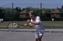 Boy playing shot close to net.