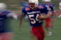 Blurred action shot of the Brighton B-52s quarter back running with the ball