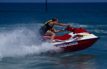 Man riding a jet ski on the sea at Littlehampton in West Sussex  England.  Viewed from the side.