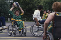 Young physically disabled adults playing wheelchair basketball.