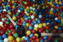 Child playing in multi coloured fun balls