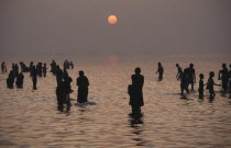 Pilgrims bathing in the River Ganges at sunset.