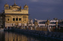 The Sikh Golden Temple with people on the walkway across the waterAsia Asian Bharat Inde Indian Intiya Religion Religion Religious Sihism Sikhs