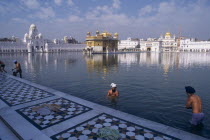 Golden Temple. Men bathing in the sacred pool surrounding the temple.Asia Asian Bharat Inde Indian Intiya Male Man Guy Religion Religious