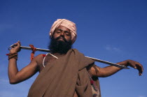 SIkh man holding Holy Kirpan Sword for the defence of the weak.  Three-quarter view looking up from below.Asia Asian Bharat Defense Inde Indian Intiya Male Men Guy One individual Solo Lone Solitary R...