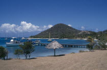 Golden beach with umbrellas and hills in the distanceBeaches Caribbean Resort Sand Sandy Scenic Seaside Shore Tourism West Indies Windward Islands