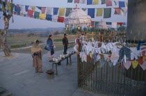 Pilgrims in front of the Ashoka pillar dating about 320 BC beside pond at sacred site where Buddha was born.