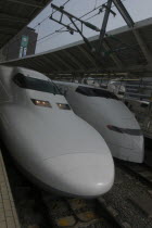 Tokyo Station  two white bullet trains at the platform nozumi shinkansen  left and hikari shinkansen  right.Asia Asian Japanese Nihon Nippon 2