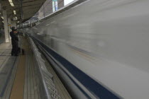 Tokyo Station  a nozomi shinkansen  bullet train leaves the station watched by Japan Railway staffAsia Asian Japanese Nihon Nippon