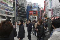 Outside Shinjuku Station  smokers light up at a smoking station  advertising on buildings.Asia Asian Japanese Nihon Nippon