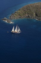 Elevated view over sailing boat passing rocky projectory.Scenic West Indies