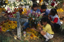 Tzurumutaro Cemetery.  Children by family grave decorated with candles and flowers for the Day of the Dead.