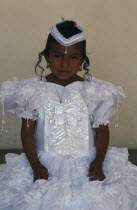 Portrait of young girl dressed in white on the day of her first communion.