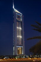 Emirates Tower illuminated at night with coloured lights and passing car in the foreground.Al-Imarat Al-Arabiyyah Al-Muttahidah Automobile Automotive Cars Colored Dubayy Emiriti Middle East Motorcar...