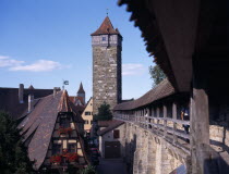 View from the town walls under covered walkway toward tower and gableDeutschland Western Europe European Bayern Bavaria