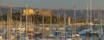 Panoramic view over moored boats in the harbour toward hilltop fortifications.