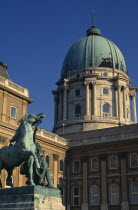 The Royal Palace  part view of exterior and domed roof with statue of man restraining horse in the courtyard in foreground.