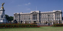 Buckingham Palace.  Front view with the Victoria Memorial to the left and red flower beds and lawns European Great Britain History Londres Northern Europe UK United Kingdom British Isles