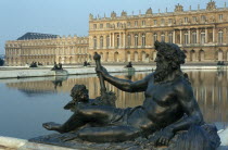 Palace with lake and statue of reclining figure in foreground.