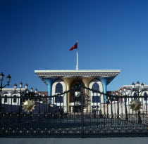 Al Alam Palace. Main entranc with blue and gold colomns ornate gates and flag