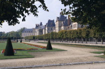 Palace and gardens framed by tree branches