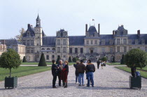 Palace of Fontainebleau with tourists in courtyard