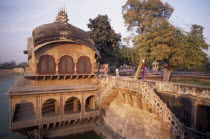 Gopal Bhavan  the Suraj Mahl s Palace built in the 18th C in Rajput and Mughal style.  Women carrying large jars on their heads across stone wall.