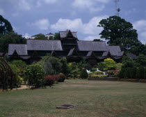 The Sultans Palace viewed from across green lawn with flowers and bushes with pathway and white steps