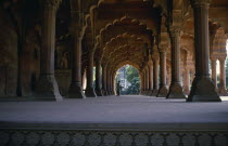 View down colonnade of ornate arches with couple standing at far end.