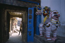 Dubar Square. Royal Palace or Hanuman Dhoka. Statue of Shakti riding a lion next to private entrance to palace with a guard seen through doorway