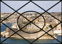 Fort Saint Angelo on Vittoriosa one of the Three Cities in Valletta Harbour seen through the metal railings of the Upper Barrakka Gardens in Valletta