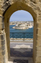 Fort Saint Angelo on Vittoriosa one of the Three Cities in Valletta Harbour seen through an arch in the Upper Barrakka Gardens in Valletta