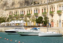 The waterfront redevelopment of old Baroque Pinto wharehouses below the bastion walls of Floriana beside the cruise ship terminal with boats moored alongside