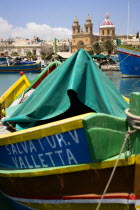 Fishing village harbour on the south coast with colourful Kajjiki fishing boats and the Church dedicated to Our Lady of the Rosary The Madonna of Pompeii