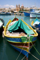 Fishing village harbour on the south coast with colourful Kajjiki fishing boats and the Church dedicated to Our Lady of the Rosary The Madonna of Pompeii