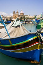 Fishing village harbour on the south coast with colourful Kajjiki fishing boats and the Church dedicated to Our Lady of the Rosary The Madonna of Pompeii