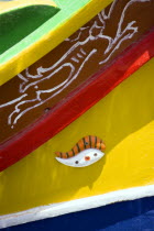 Fishing village harbour on the south coast with colourful Kajjiki fishing boat with the Eyes of Osiris on the bow