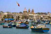 Fishing village harbour on the south coast with colourful Kajjiki fishing boats and the Church dedicated to Our Lady of the Rosary The Madonna of Pompeii