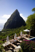 Val des Pitons Tourists sunbathing on the sun deck beside the pool at Ladera Spa Resort Hotel overlooking Petit Piton volcanic plug and Jalousie beach