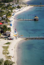 The coconut palm tree lined beach at Sandals Grande St Lucian Spa and Beach Resort hotel with tourists walking  swimming or sunbathing