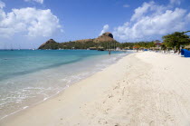 The beach at Sandals Grande St Lucian Spa and Beach Resort hotel with Pigeon Island National Historic Park beyond