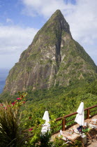 Val des Pitons The volcanic plug of Petit Piton and the lush valley seen from the sun deck of the Ladera Spa Resort Hotel with tourists sunbathing on sunbeds beside umbrellas