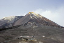 View of active and smoking main crater of volcano and older crater with visitors and transportation vehicles in foreground.earthtrekingclimbingtourismgeologygeologicalmountainashlavaEuropean...