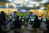 Shinjuku.  Young Japanese seated in front of computer screens soccer video game.footballurban lifemodern livingtechnologyenjoymentenjoycultureFar EastAsia Asian Immature Nihon Nippon